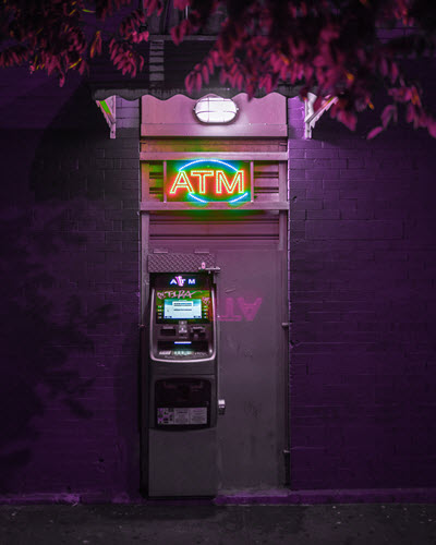 ATM in purple light. Photo by Mirza Babic on Unsplash