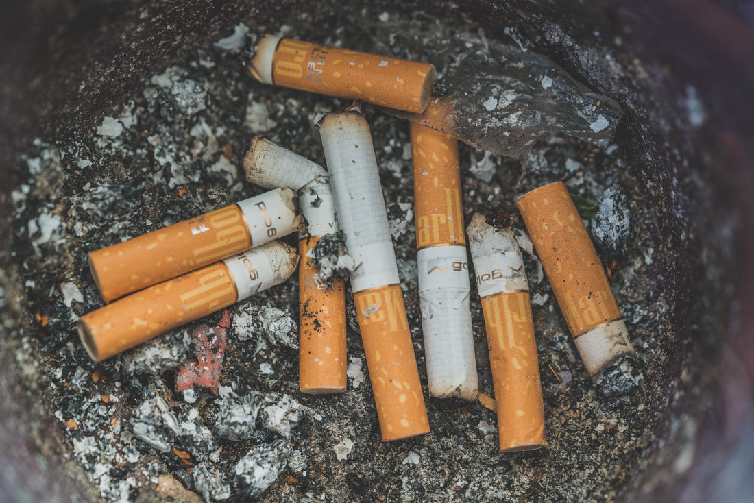 Photo by Patrick Brinksma on Unsplash - Closeup of cigarette ashtray with butts