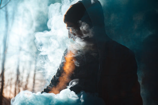 Silhouette of hooded man, surrounded by vapor